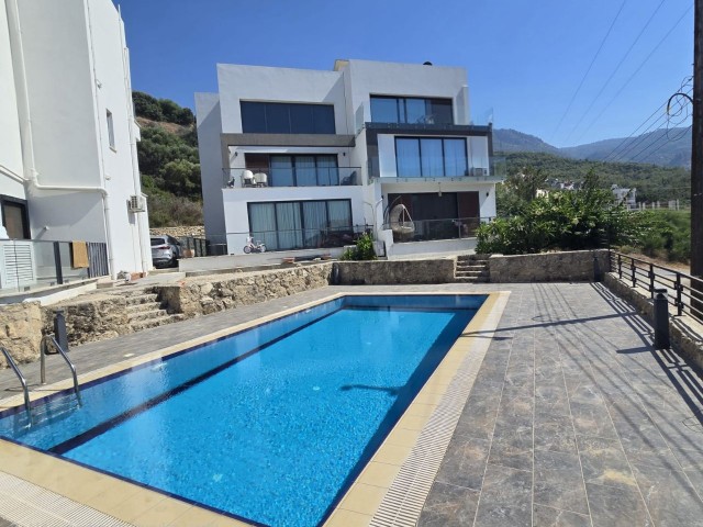 Girne Alsancak'ta önü kesilmez deniz manzaralı ve havuzlu butik site içerisinde zemin katta SATILIK 2+1 DAİRE